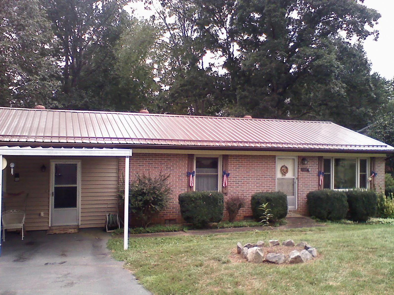 Bronze metal roof and carport on a brick ranch home — Roof Repair work by our crew in La Salle