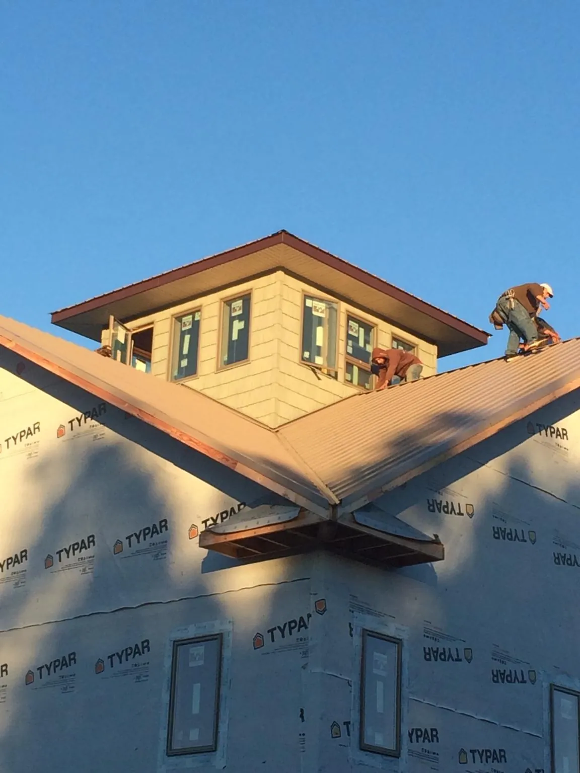 Roofers working around a rooftop cupola on a new metal roof at sunset — Roof Waterproofing in La Salle by Roofing Brothers